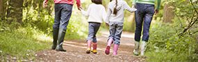 Familly walking in wellington boots during spring walk