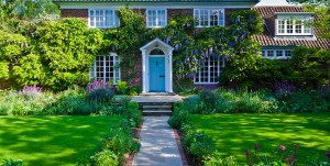 House with blue front door and laburnum around the outside