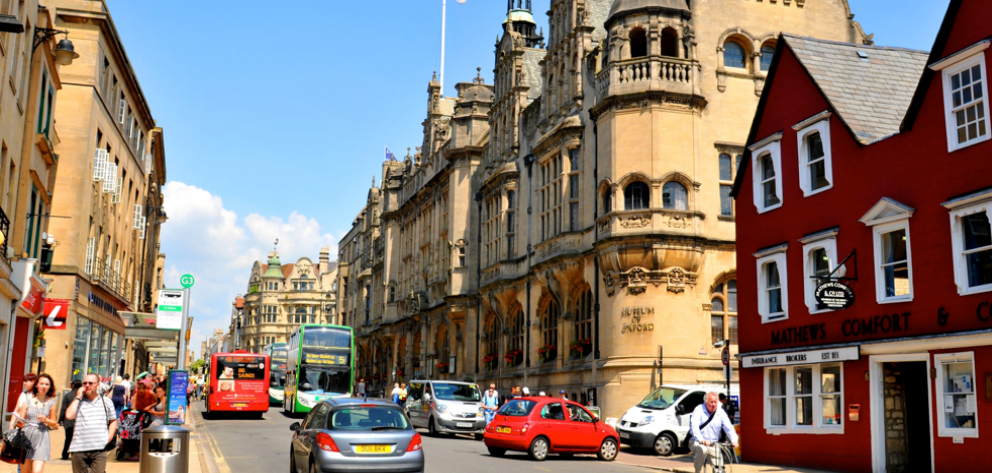 Oxford city centre with shops in the summer with people and historic buildings